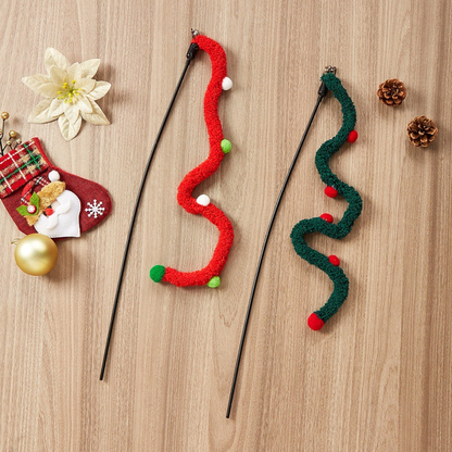 Red and dark green wavy cat teaser wands arranged with holiday decorations