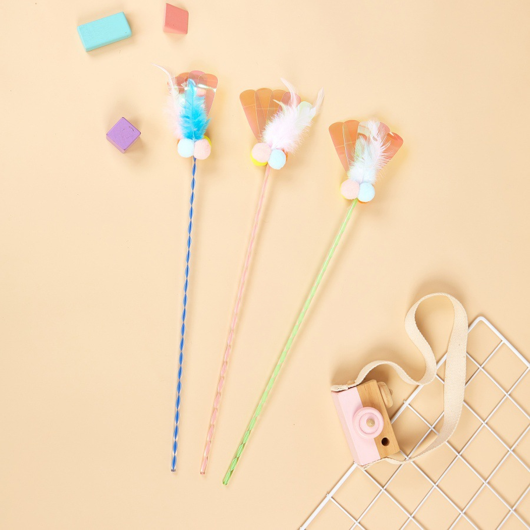 Blue, Pink, and Green cat teaser wands arranged with colorful props