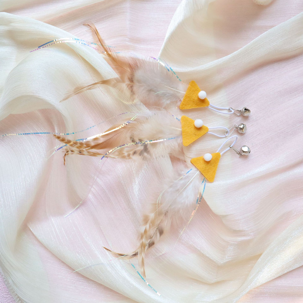 Three yellow fish-shaped cat teaser replacement attachments with feather tails and bells