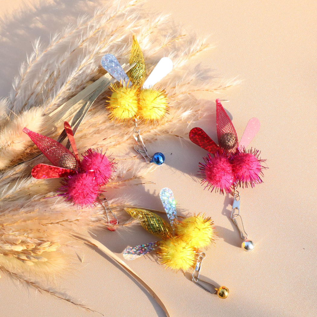 Four yellow and fuchsia winged cat toy attachments arranged together