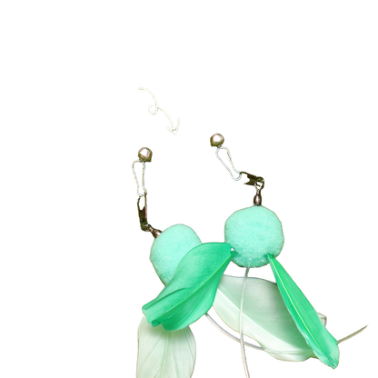 Close-up of snap hooks, bells, pom-poms and feather fins