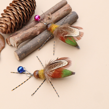Two winged insect-shaped cat toys showing patterned upper wings and orange-green lower bodies