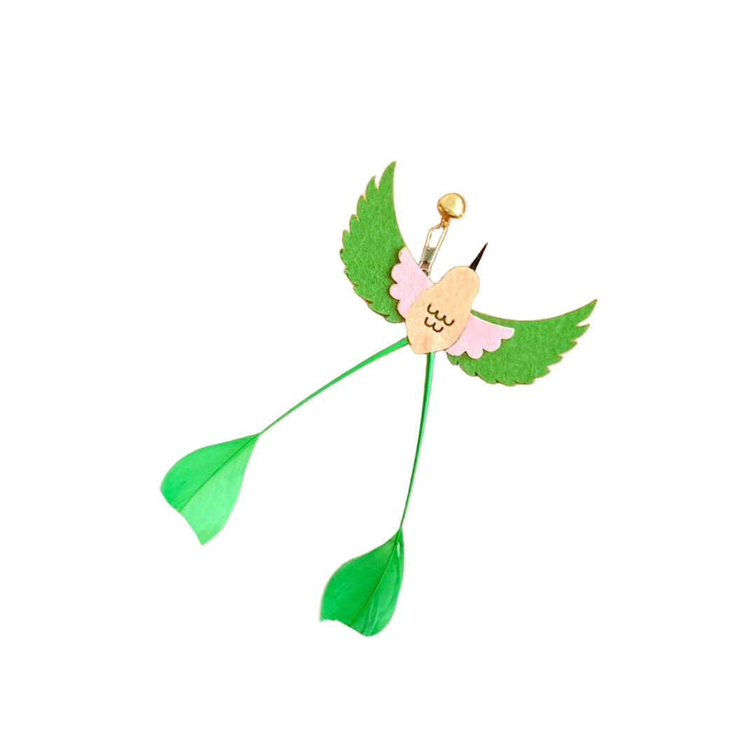 Green and pink long-tailed bird-shaped cat toy attachment displayed on a wooden tray