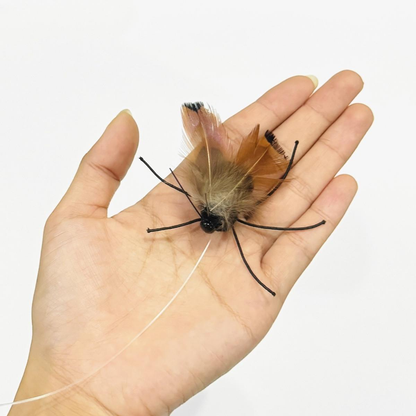 Close-up of a moth-shaped cat toy lure resting on a hand