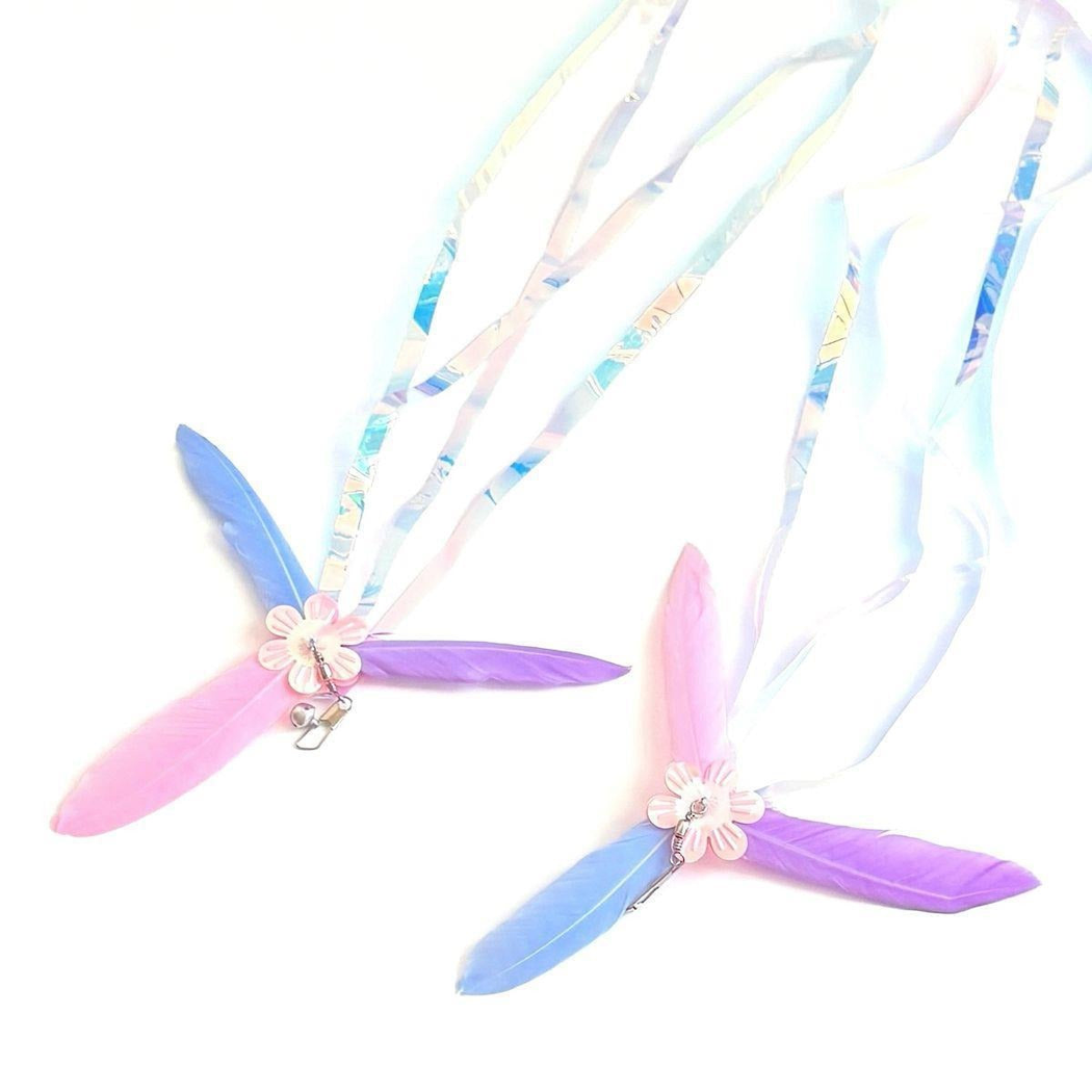 Two multicolor cat teaser attachments displayed with flower centers and flowing iridescent streamers
