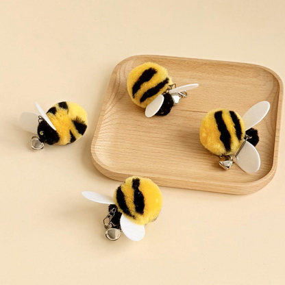 Four yellow-and-black bee cat teaser attachments arranged around a wooden tray