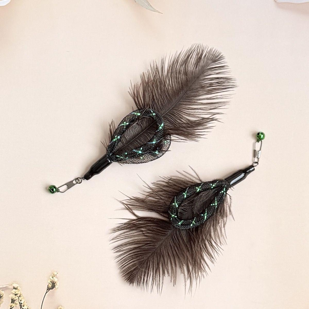 Two dark feather cat wand attachments arranged in opposite directions