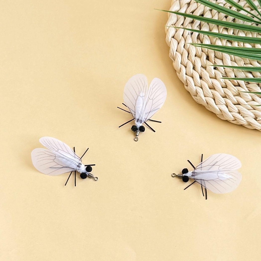 Three white moth-shaped cat toys with translucent veined wings and metal loops