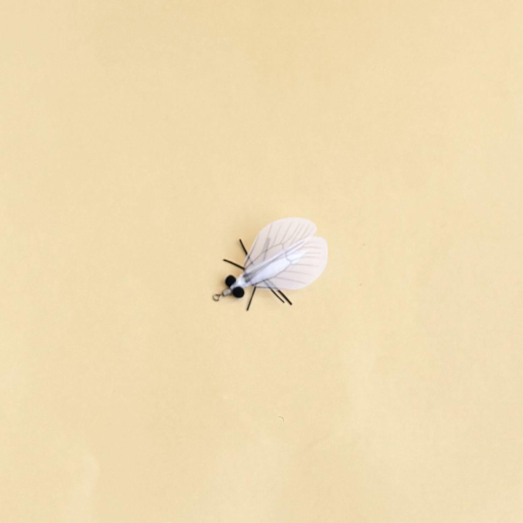 White moth-shaped cat toy with translucent veined wings and a metal loop