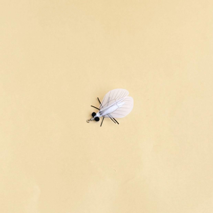 White moth-shaped cat toy with translucent veined wings and a metal loop