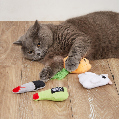 Cat playing with four Halloween cat toys on a wood floor