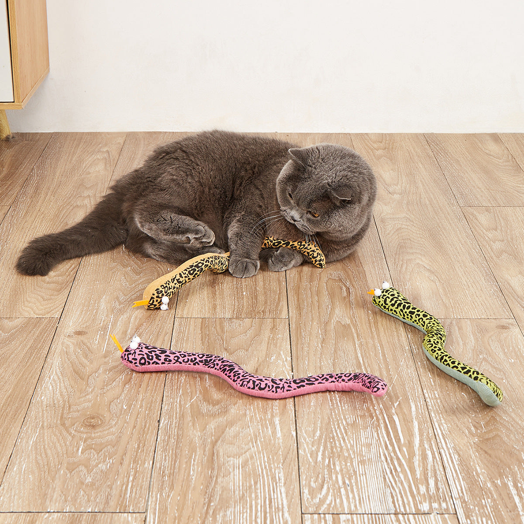Cat playing with pink, yellow and green spotted snake-shaped toys