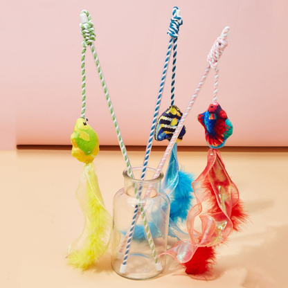 Red, blue and yellow fish wand cat toys arranged in a glass jar
