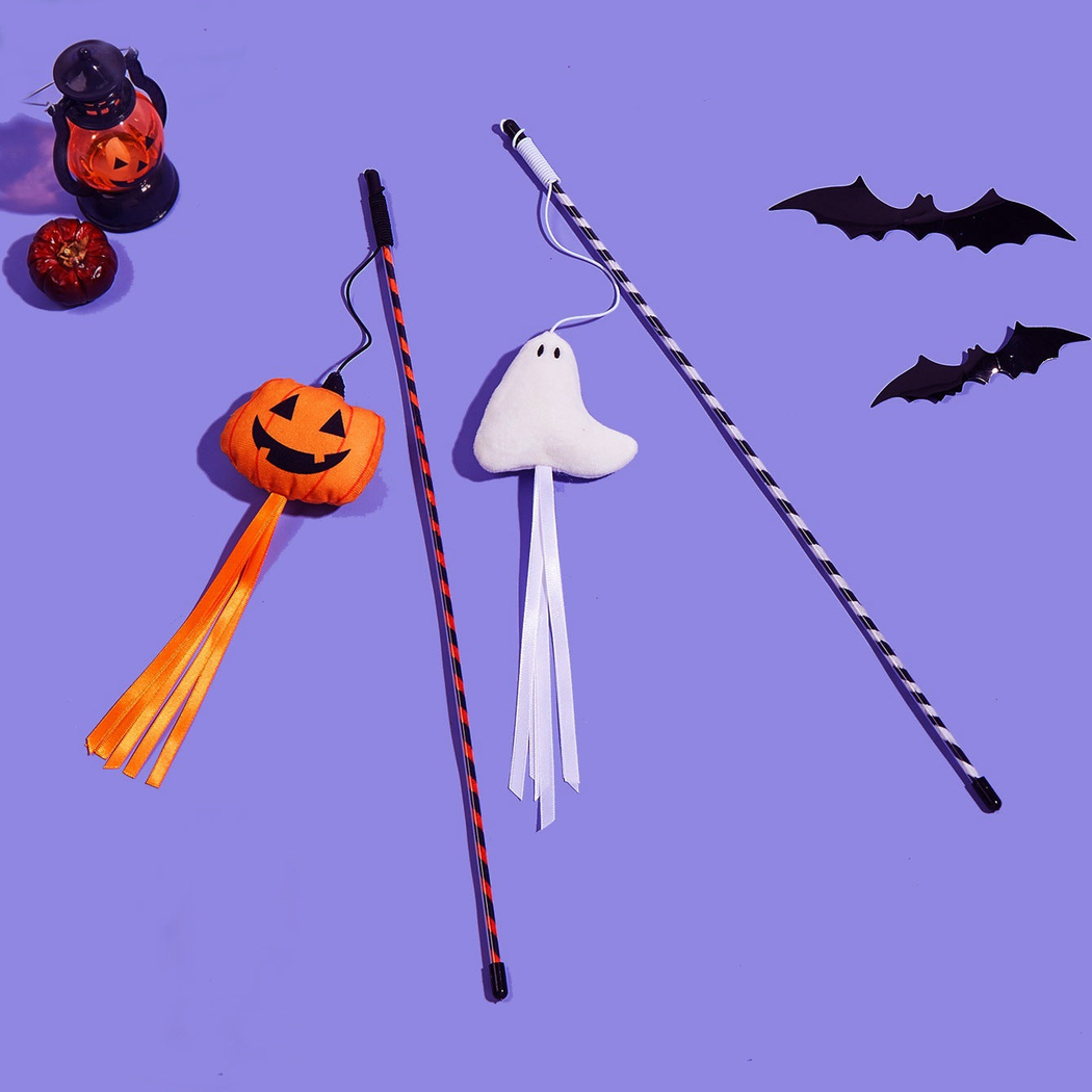 White ghost and orange pumpkin wand cat toys displayed on a purple background