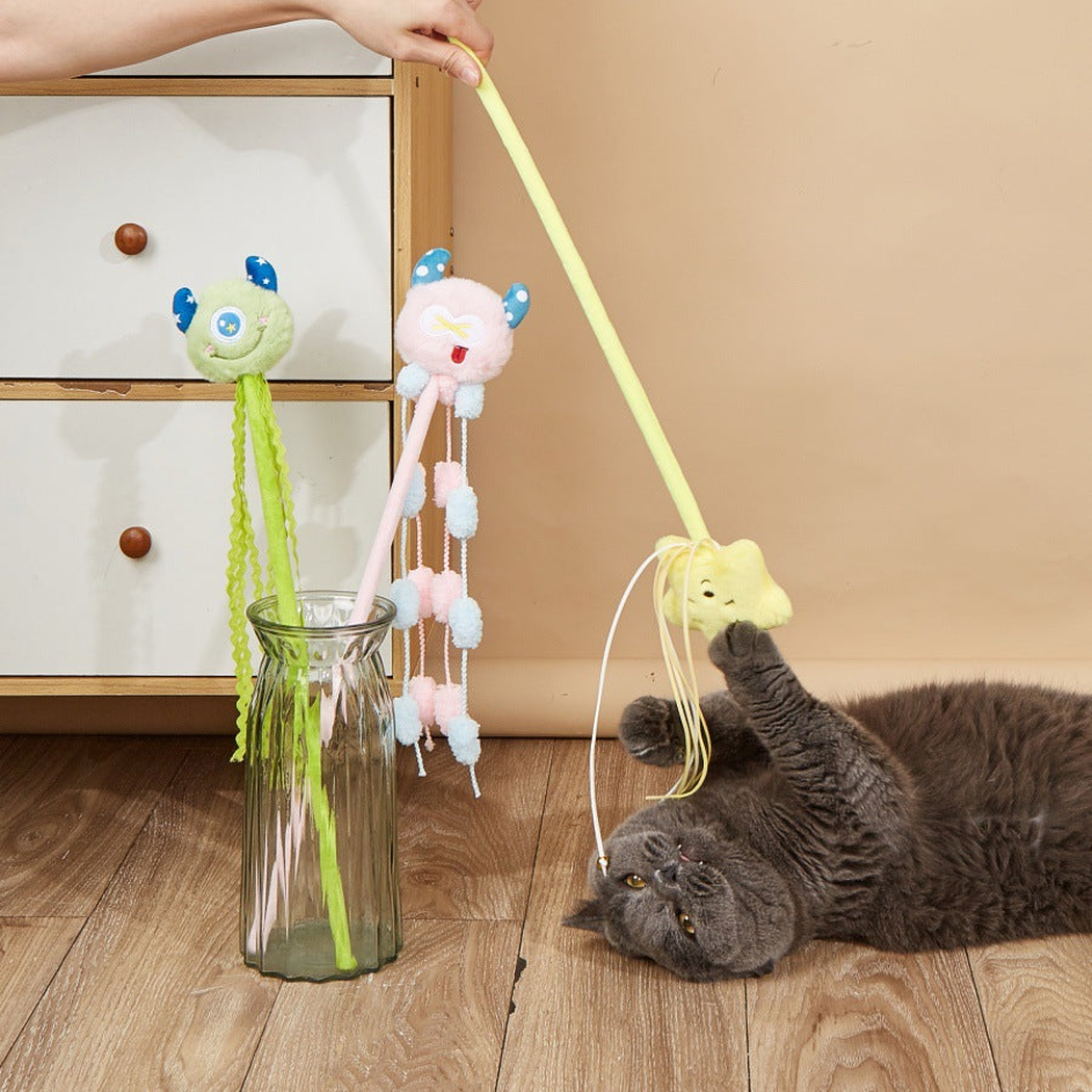Cat playing with a Star wand toy beside the Alien and Monster styles