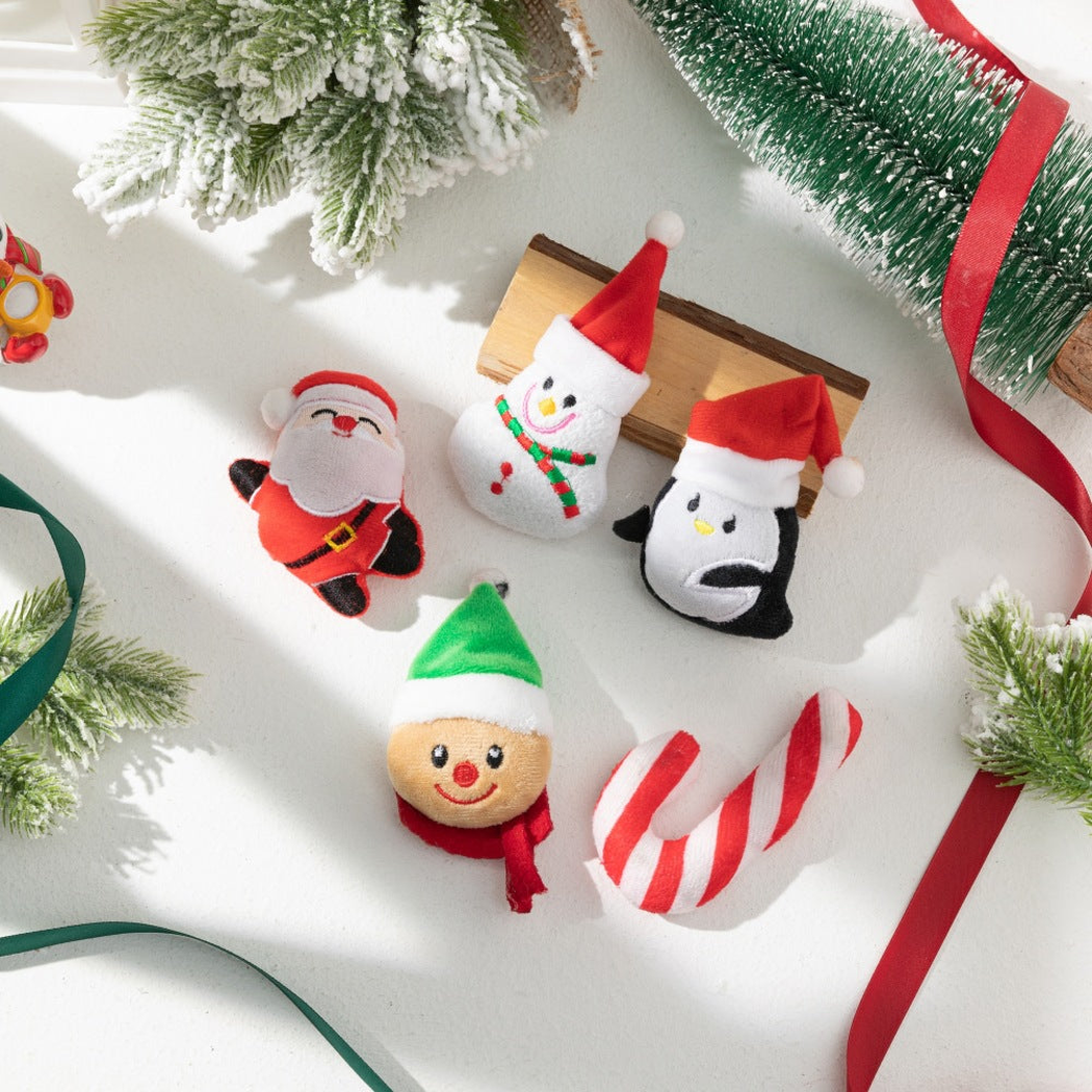 Five Christmas character cat toys arranged with festive greenery and ribbons