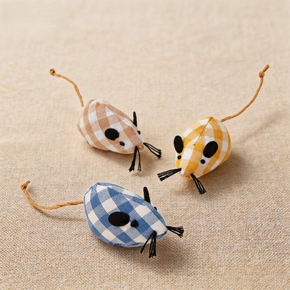 Three gingham mouse-shaped cat toys on a textured neutral surface