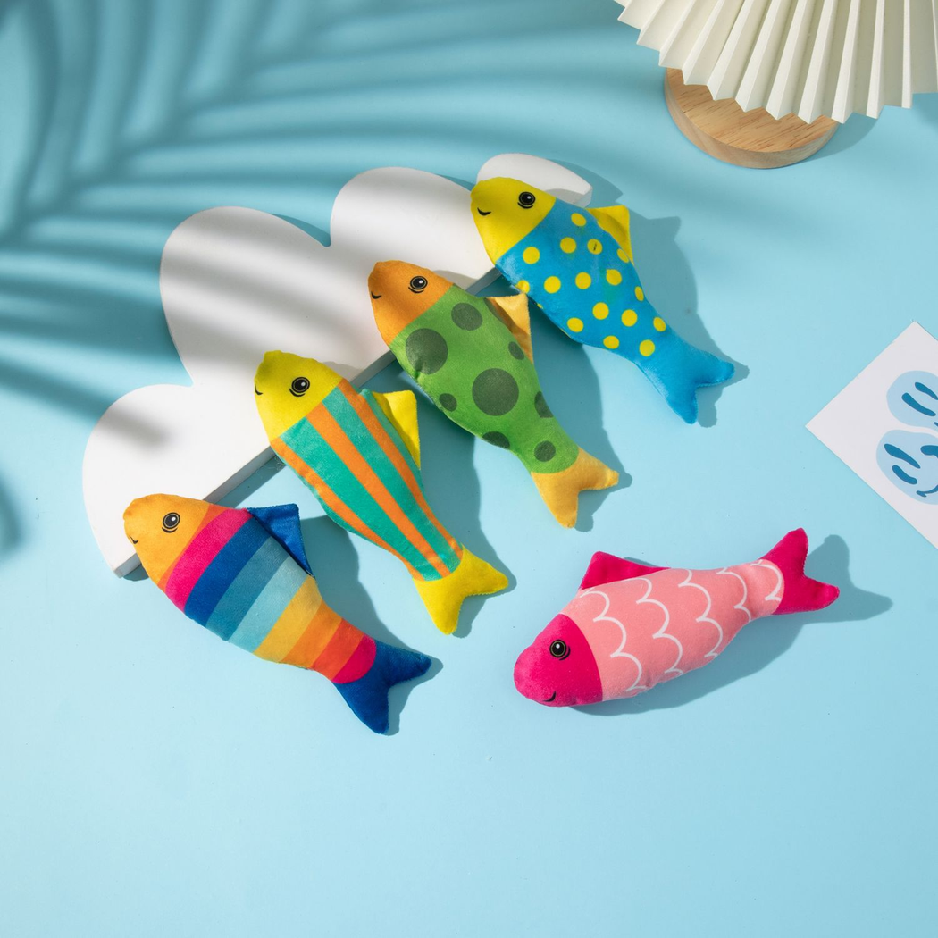 Five colorful fish-shaped cat toys arranged on a blue background