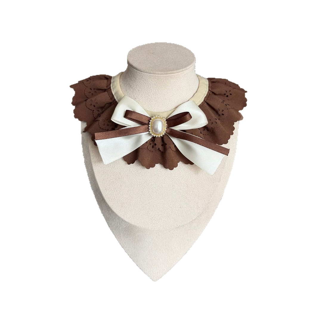 Brown decorative pet neckwear with layered ruffles, ribbon bow, and oval pearl-look centerpiece