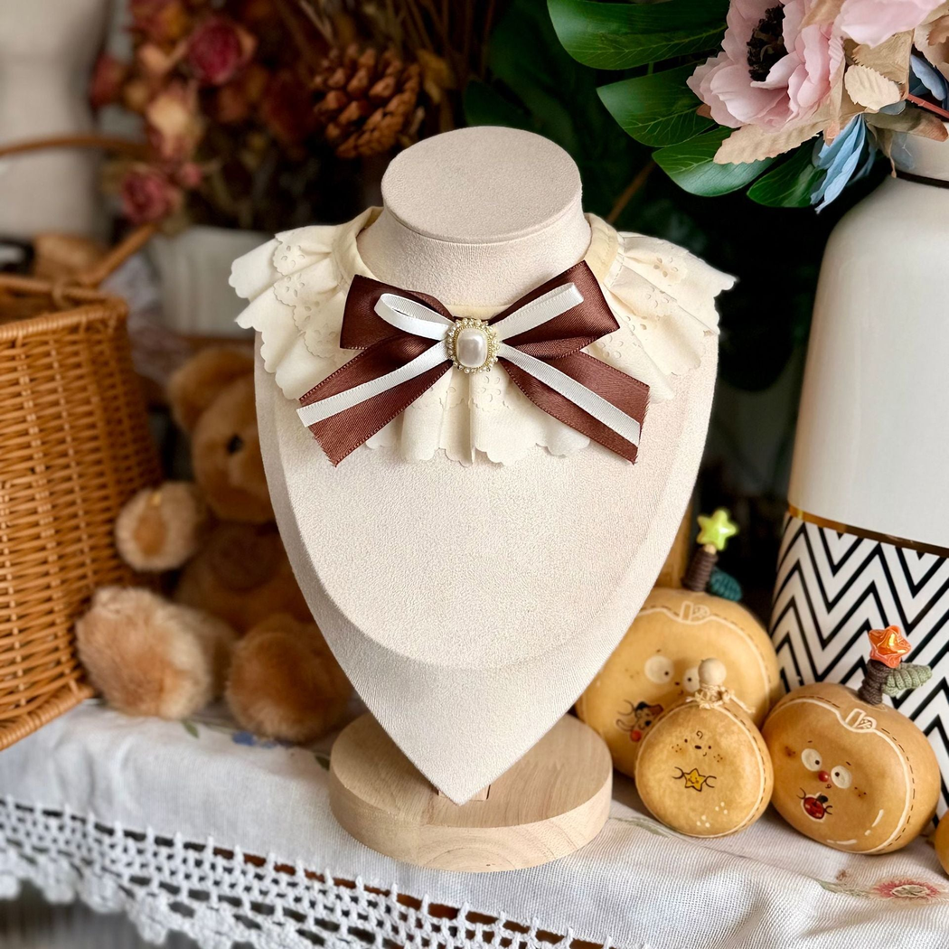 Ivory decorative pet neckwear with scalloped ruffles and a contrasting brown ribbon bow