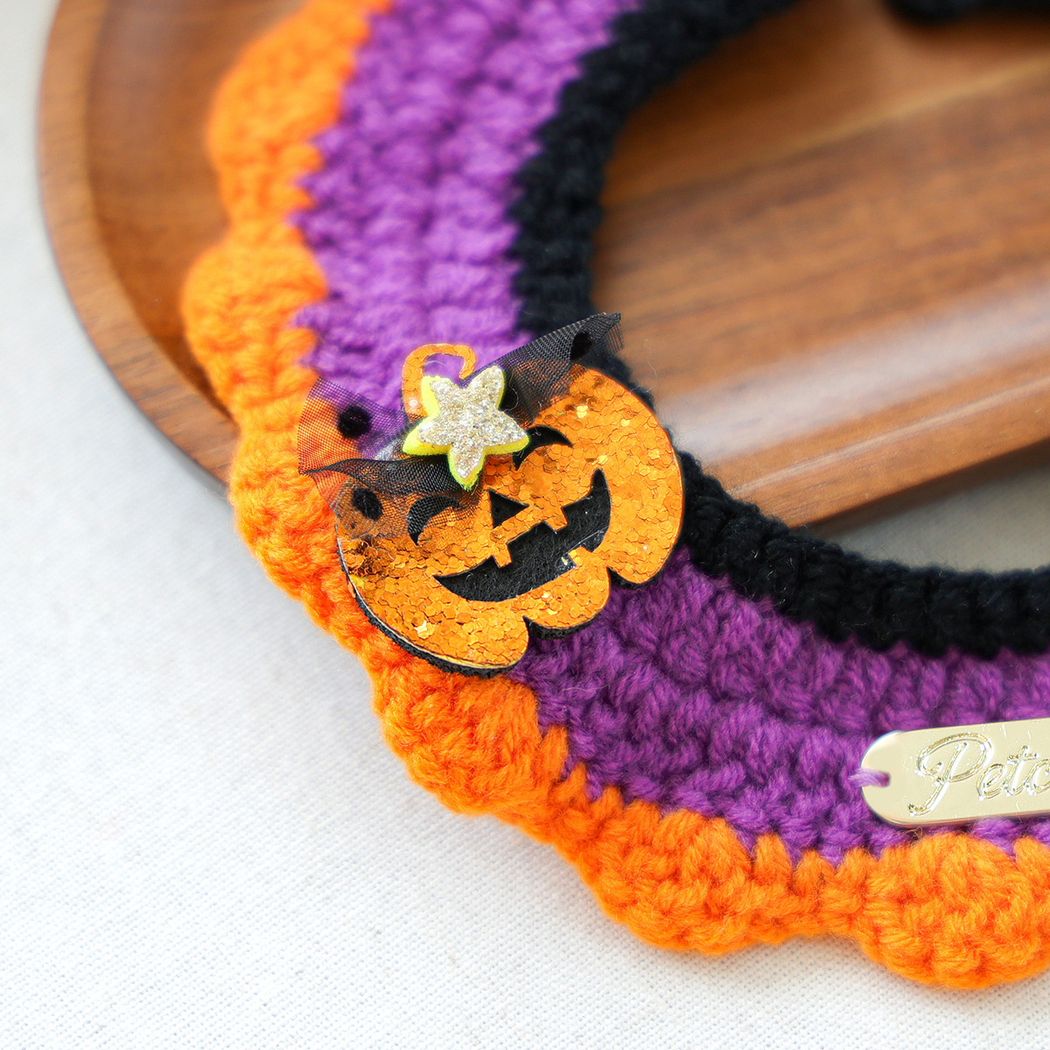 Close-up of the glitter pumpkin accent and orange scalloped edge on Pumpkin Ghost cat neckwear