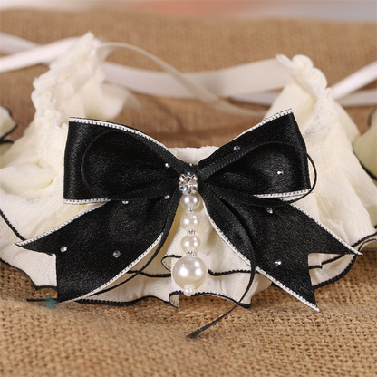 Ivory ruffled pet neckwear with black bow and graduated pearl-look drop