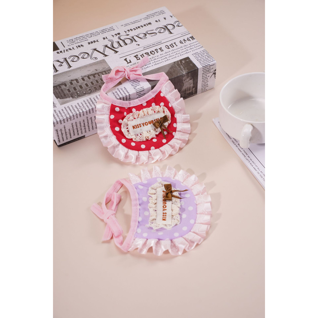 Red and light purple polka-dot pet neckwear arranged with tabletop props