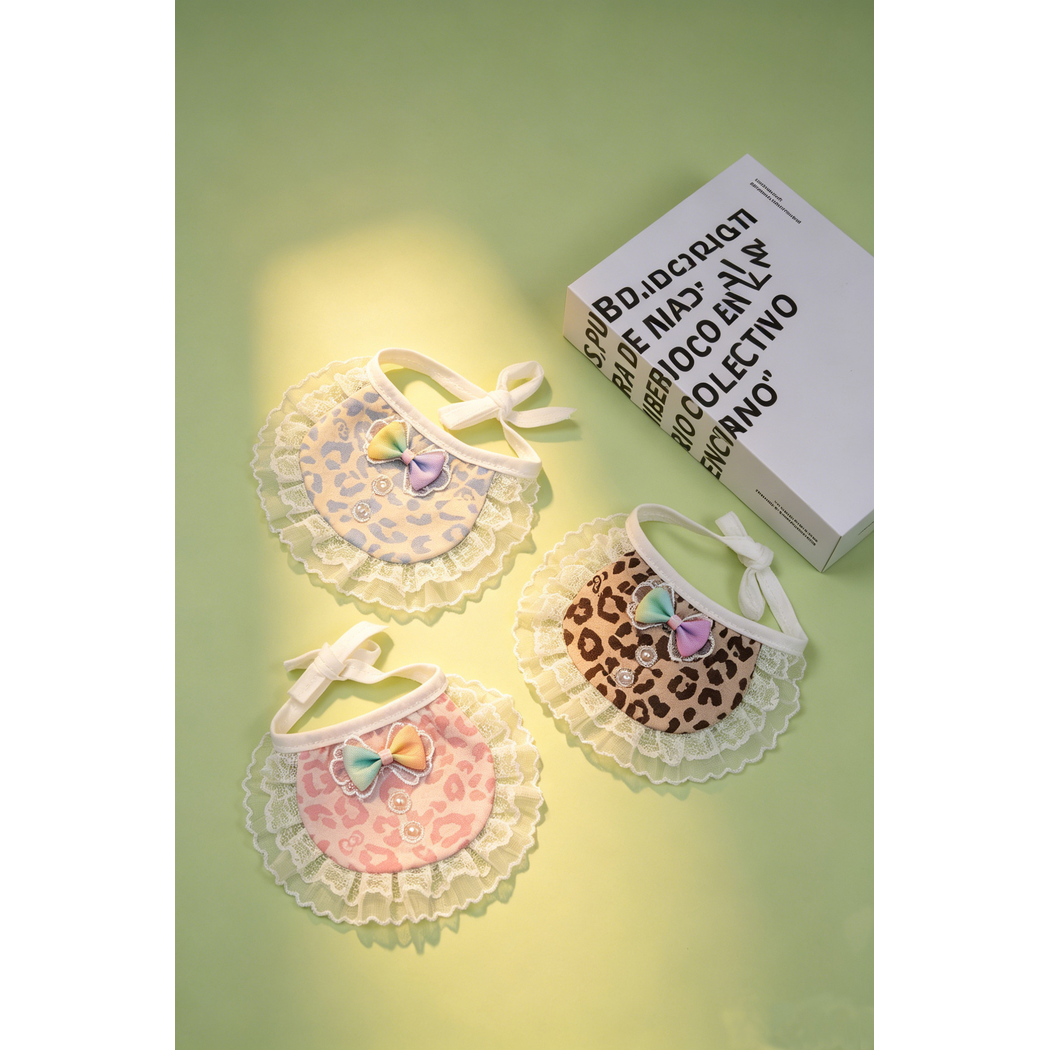 Three leopard-print pet neckwear colors arranged under warm light on a green surface