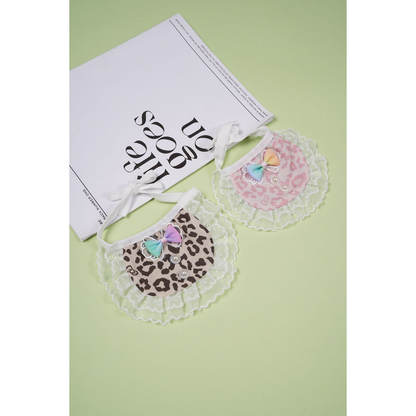 Brown and pink leopard-print pet neckwear displayed beside a book prop