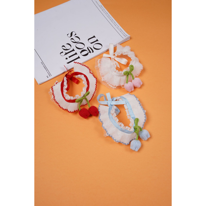 Red, light pink, and light blue pleated pet neckwear arranged on an orange background