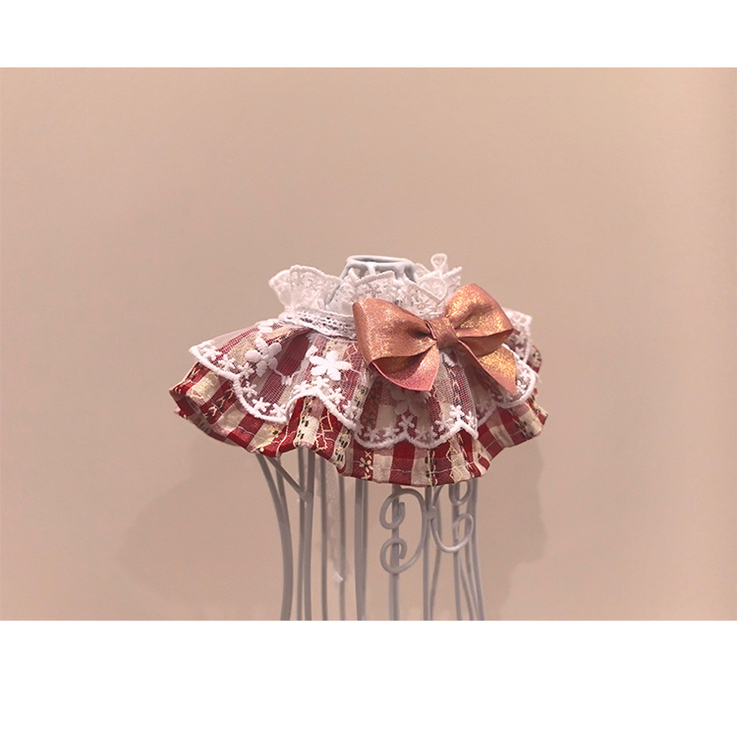 Red plaid pet neckwear with scalloped white trim and a metallic pink bow, opposite angled view
