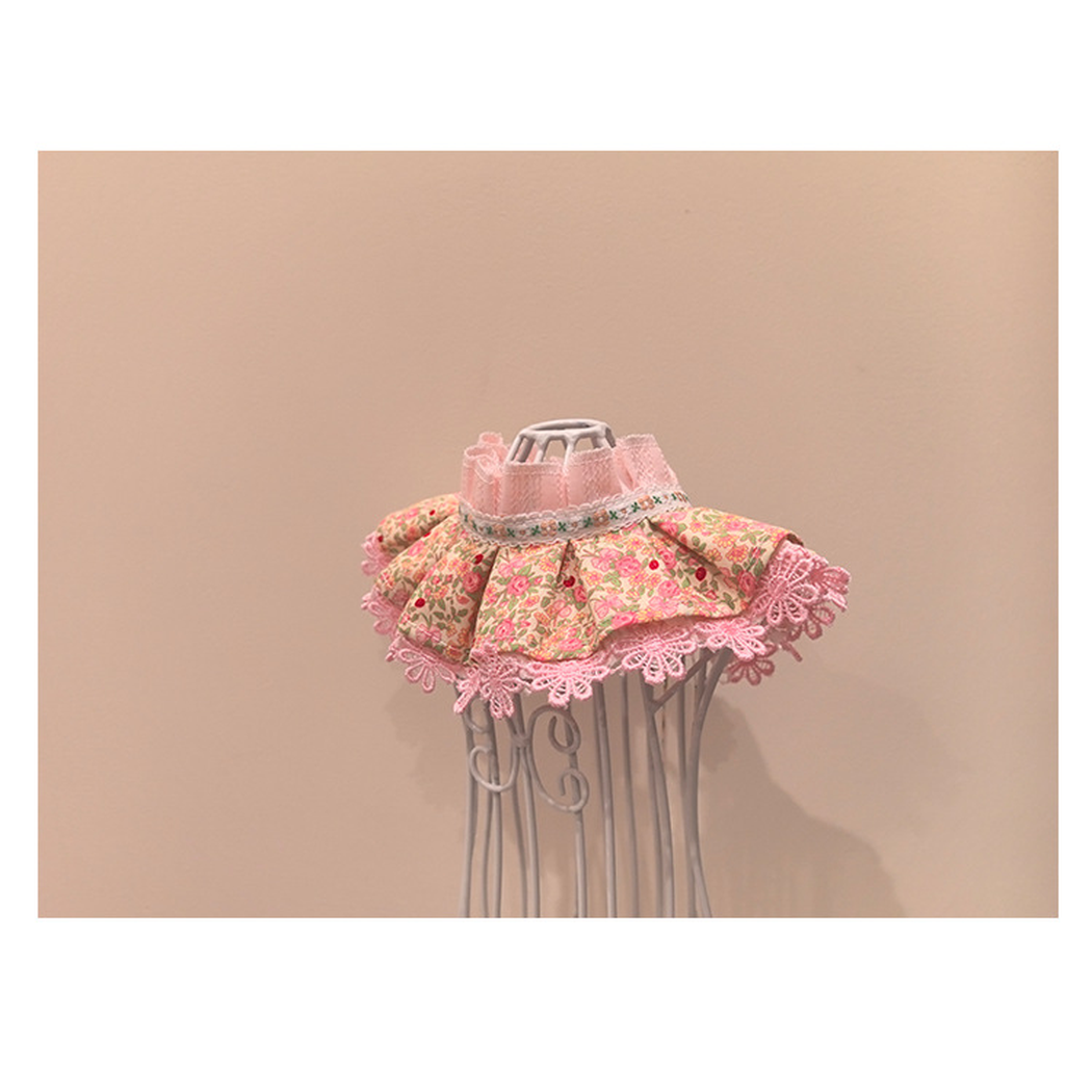 Pink floral pet neckwear with ruffled neckline and flared pleats, right angled view