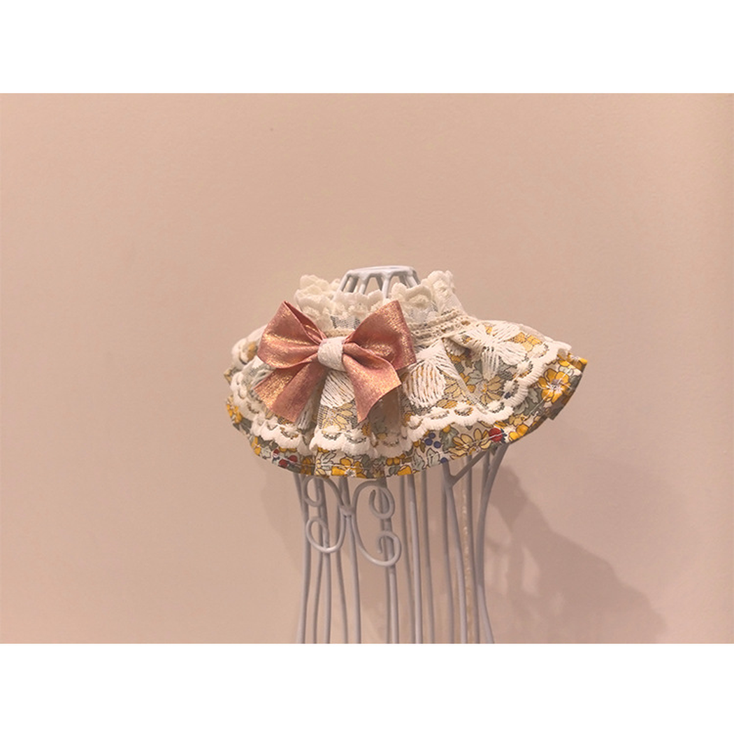 Floral pet neckwear with layered trim and rose-pink bow, opposite angled view