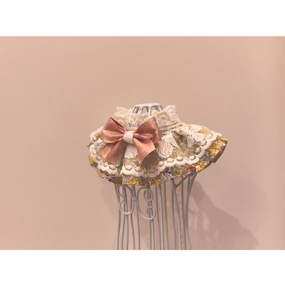 Floral pet neckwear with layered trim and rose-pink bow, opposite angled view