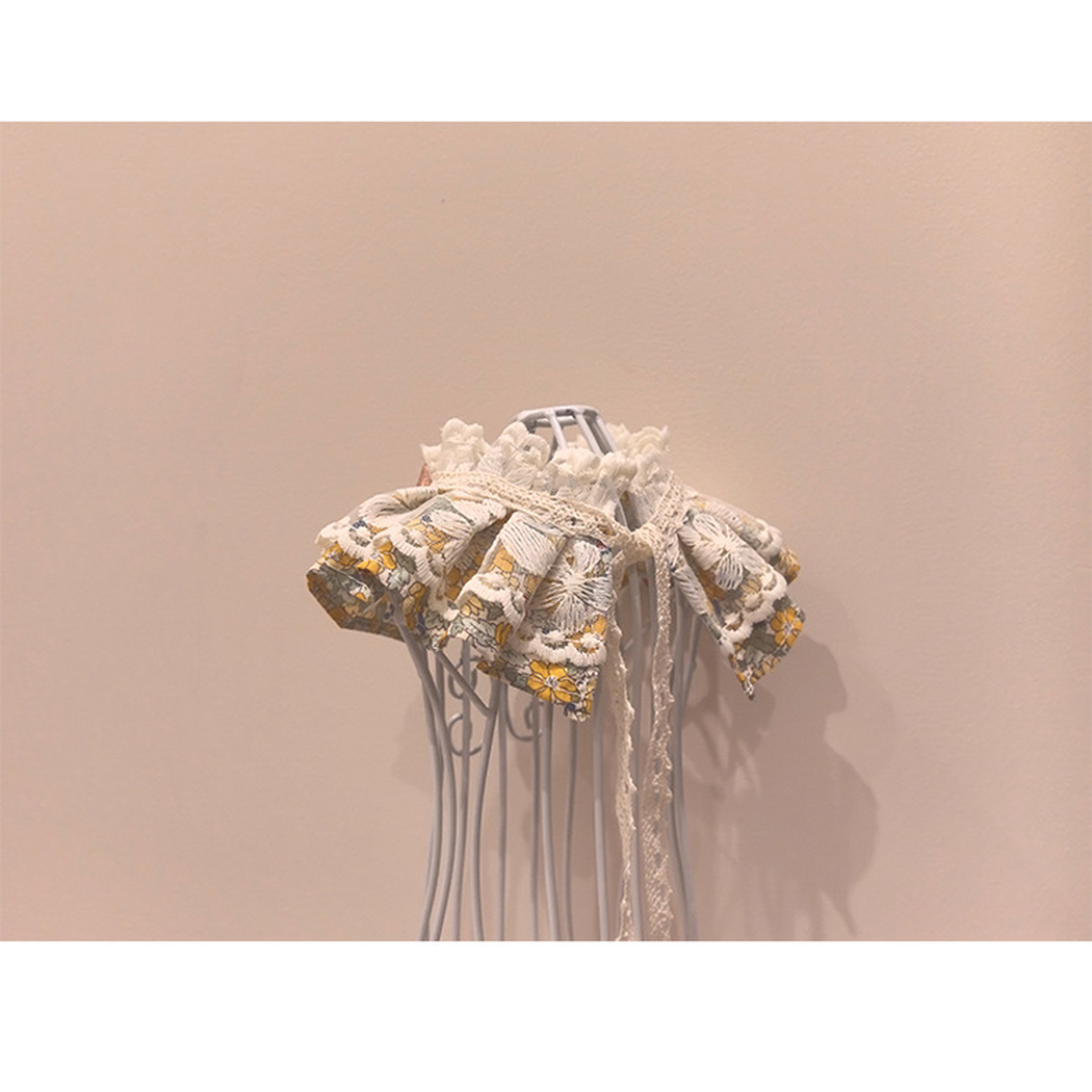 Back detail of floral pet neckwear with lace-look ties and layered ruffles