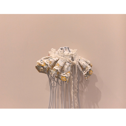Back detail of floral pet neckwear with lace-look ties and layered ruffles