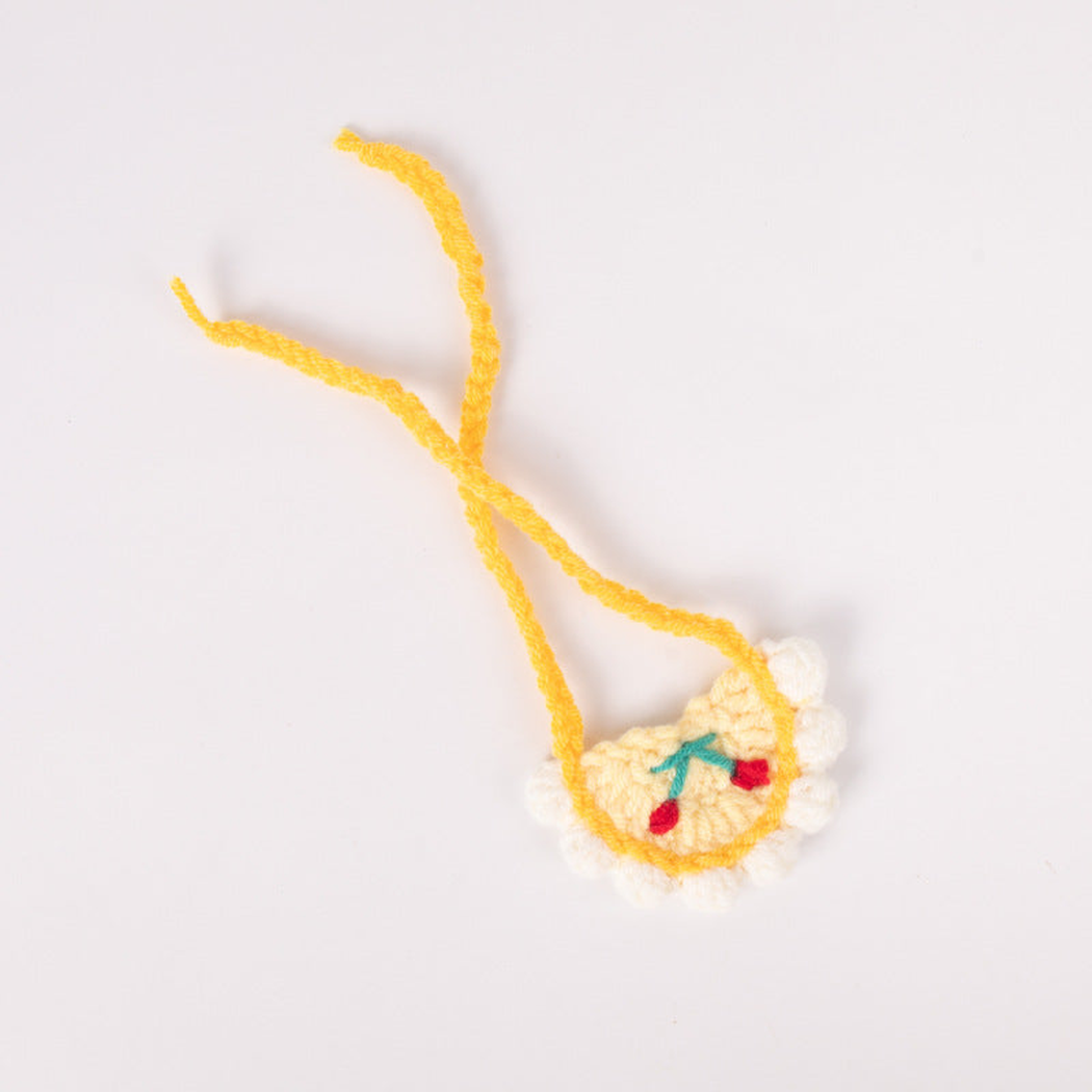 White pet neckwear with yellow trim and cherry motif, flat view