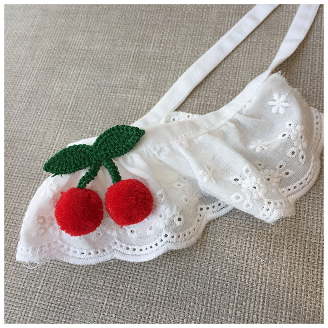 Angled close-up of the cherry accents and layered white ruffle