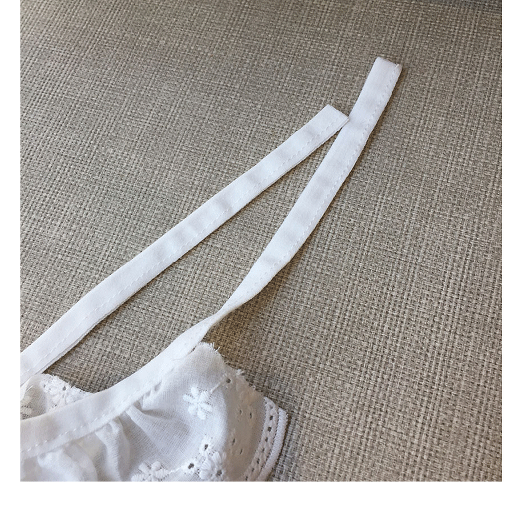 Close-up of the long white tie straps and ruffled edge attachment