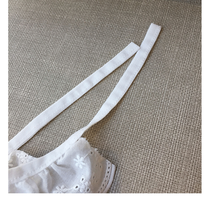 Close-up of the long white tie straps and ruffled edge attachment