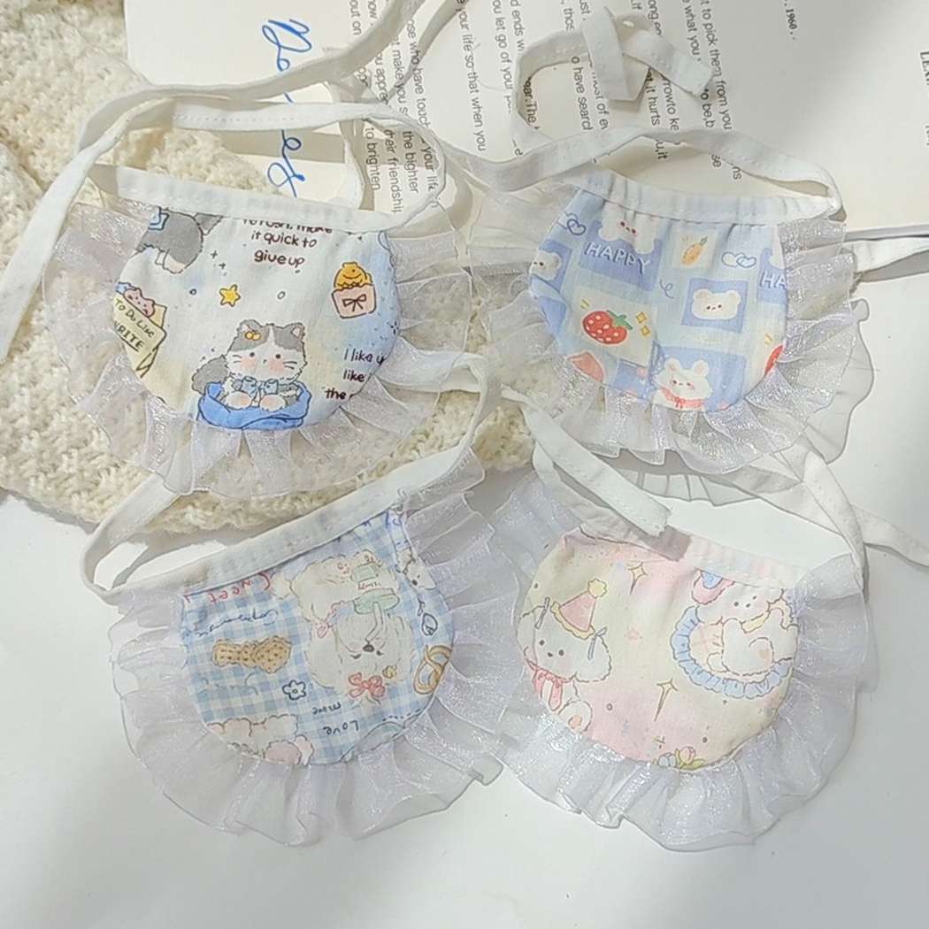 Four pastel cartoon-print pet neckwear styles arranged with their white ruffled borders and tie straps visible