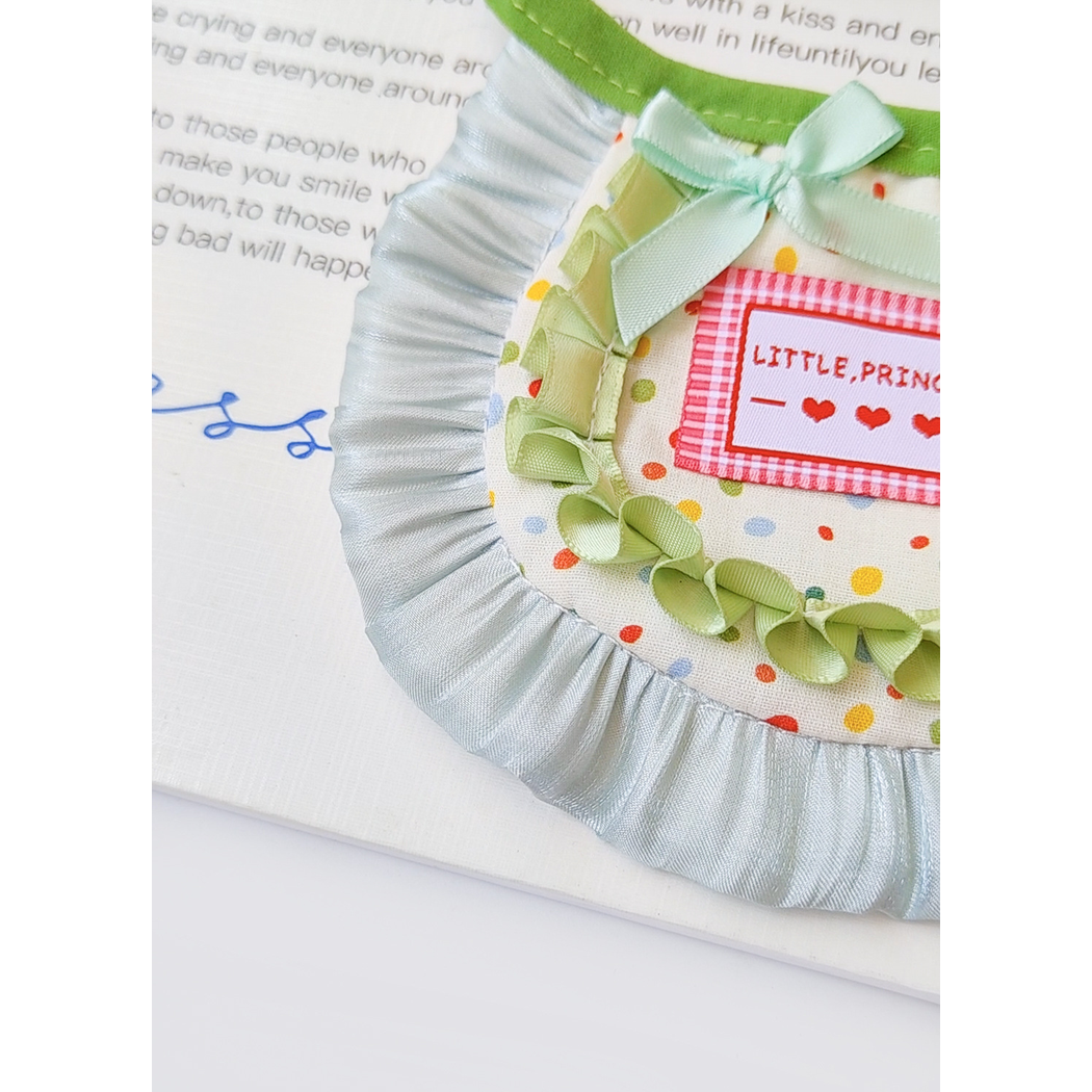 Close-up of the green bow, polka-dot panel and pale blue ruffle edge