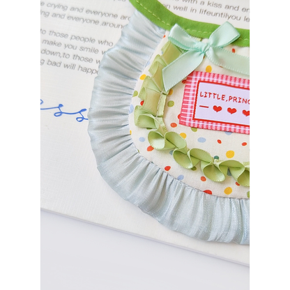 Close-up of the green bow, polka-dot panel and pale blue ruffle edge