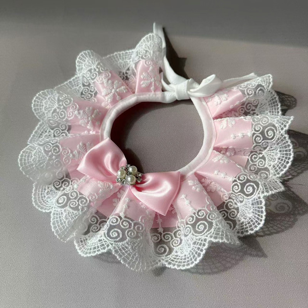 Pink ruffled pet neckwear laid flat with bound opening and tie straps visible