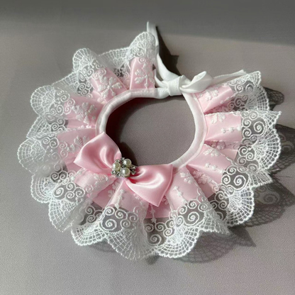 Pink ruffled pet neckwear laid flat with bound opening and tie straps visible