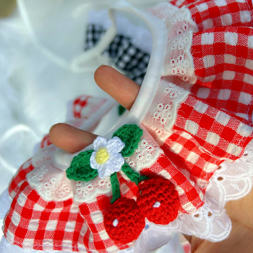 Close-up of red gingham ruffles, white lace-look edging and fruit ornaments