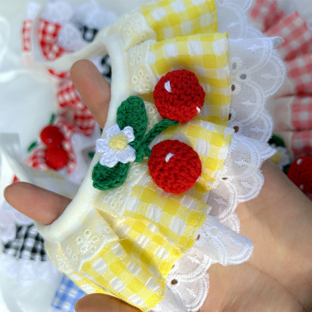 Close-up of yellow gingham ruffles, white lace-look edging and fruit ornaments