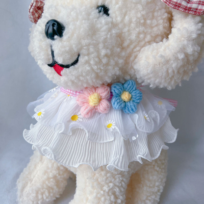 Pink ruffled pet neckwear with flower appliqués displayed on a plush animal