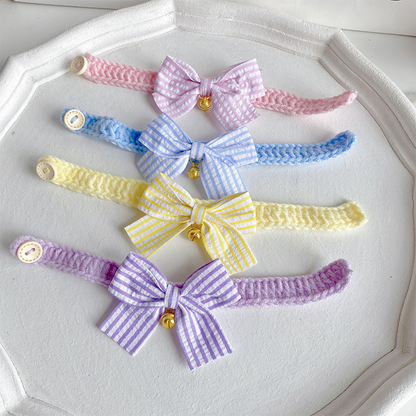 Yellow, blue, light purple and light pink cat collars with striped bows and bells