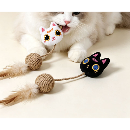 Cat biting the white cat-head toy beside the black version